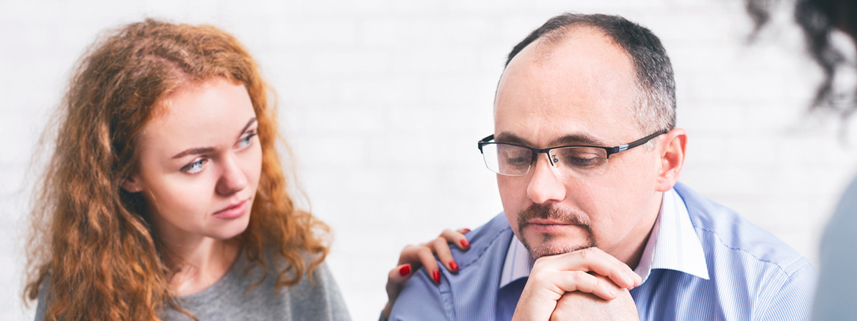  Supportive wife comforting husband with TRD during a meeting with a counselor in Duluth.