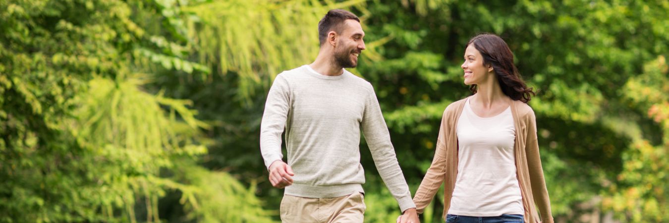 A couple walking hand in hand at a park during summer season enjoying life after rehab in Duluth
